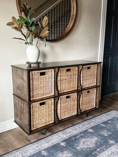 a wicker cabinet with four baskets on top and a round mirror over the door