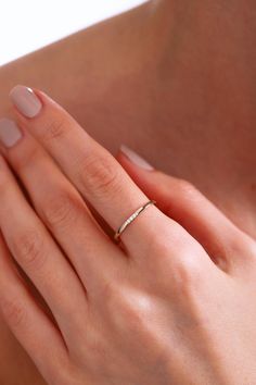 a woman's hand with a gold ring on her left hand and a diamond band