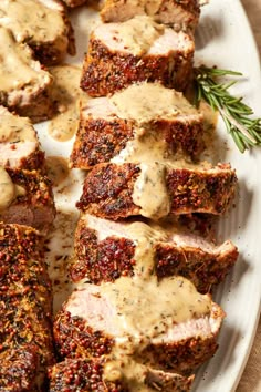 meatloaf with gravy and herbs on a white platter, ready to be eaten