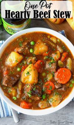 a bowl of hearty beef stew with carrots, potatoes and parsley on the side