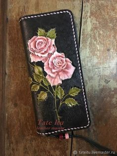 a leather wallet with pink roses painted on it