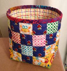 a colorful patchwork basket sitting on top of a table