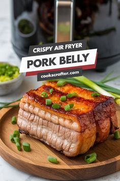 pork belly on a wooden plate with green onions and seasoning next to the air fryer