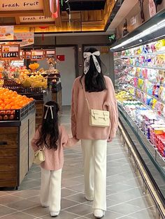 two people are walking through a grocery store