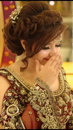 a woman in a red and gold dress is holding her hands to her face as she looks into the mirror