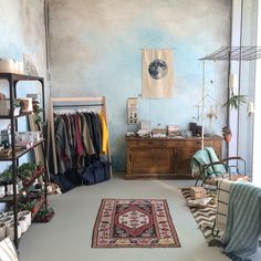 a room filled with lots of furniture and rugs next to a wall painted blue