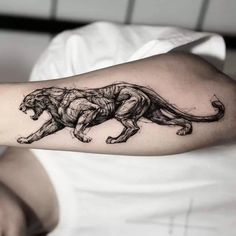 a black and white photo of a lion tattoo on the arm