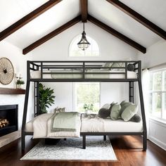 a bedroom with a bunk bed and fireplace in the corner, surrounded by wood flooring