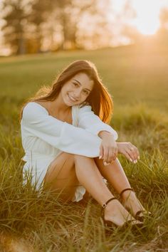 a woman sitting in the grass with her legs crossed