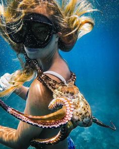 a woman with an octopus on her back in the water, wearing goggles and snorkels