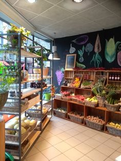 a store filled with lots of different types of vegetables and fruits in baskets on shelves