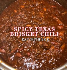 spicy texas brisket chili in a pot with text overlay that reads, spicy texas brisket chili eat with joe