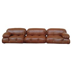 a brown leather couch with two reclinings on it's back and one end facing