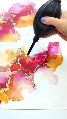 a person is painting with acrylic paint on paper