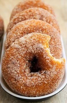 sugar covered doughnuts in a white dish on a table