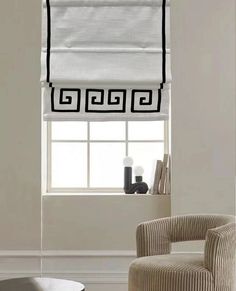 a chair sitting in front of a window with roman blinds on the windowsills