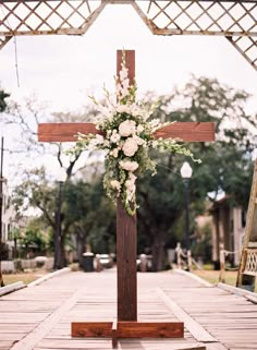 a wooden cross with flowers on it