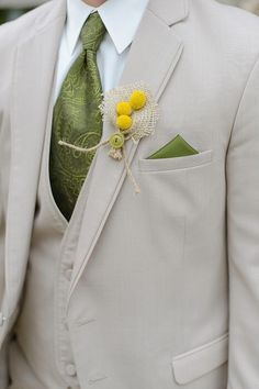 a man wearing a suit and tie with a flower in his lapel pin on his lapel