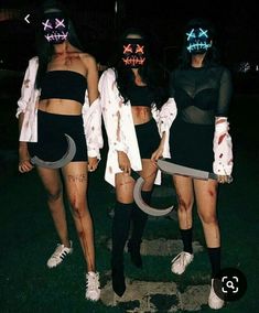 three women in costumes with neon masks on their faces