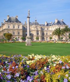 a large building with lots of flowers around it