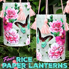 two bags with pink flowers and butterflies on them hanging from strings in front of green leaves