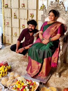 a man and woman sitting on a chair in front of food