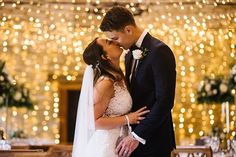 a bride and groom kissing in front of lights