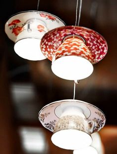 three different lights hanging from the ceiling in a room with red and white decorations on them