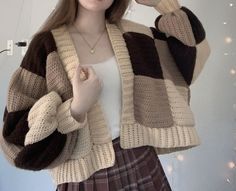 a woman is taking a selfie with her cell phone and wearing a knitted sweater