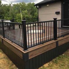 a deck with black iron railing and wooden steps