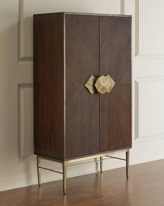 a wooden cabinet sitting on top of a hard wood floor next to a white wall