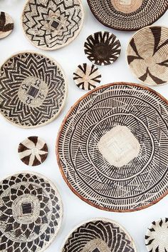 several woven baskets are arranged in rows on a white surface, one is black and the other is brown