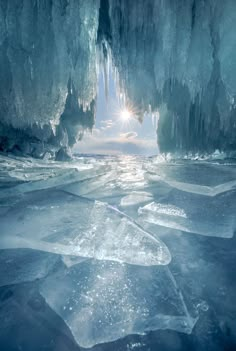 the sun shines through an ice cave with frozen water and icicles on it