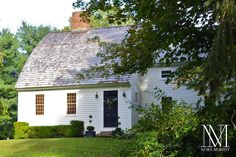 a white house surrounded by trees and bushes