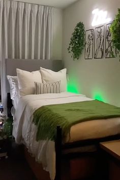 a bed with white and green sheets in a room