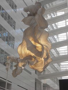 a large chandelier hanging from the ceiling in an office building with glass windows