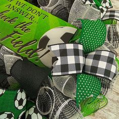 a green and white wreath with soccer balls on it's side, next to a book that says i well don't know how to say football