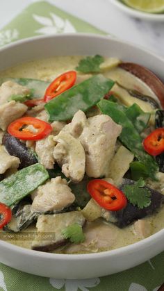 a white bowl filled with chicken and vegetables