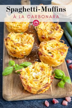 spaghetti muffins on a cutting board with basil leaves