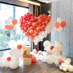 balloons are arranged in the shape of a heart on a table next to a window