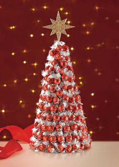 a christmas tree made out of candy and wrapped in red ribbon with a star on top