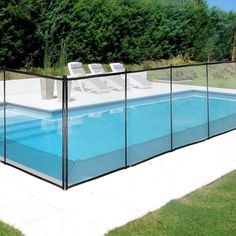 an empty swimming pool surrounded by grass and trees