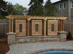 an outdoor hot tub in the middle of a patio with wooden privacy screens on it