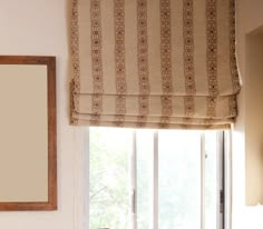 a bathroom with a sink, mirror and window coverings on the windowsill in front of it