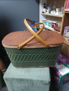 a basket sitting on top of a green chair next to a shelf with other items