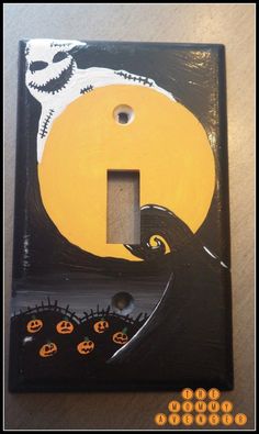 a light switch cover with a skeleton and pumpkins painted on the front in black