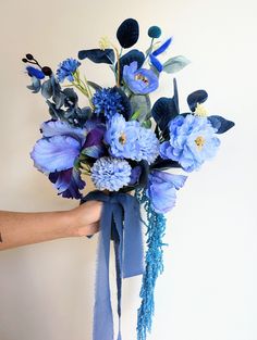 a person holding a bouquet of blue flowers