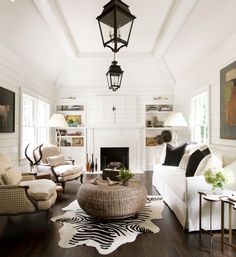 a living room filled with furniture and a fire place in front of a white wall