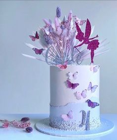 a white cake decorated with pink and purple butterflies