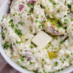 a white bowl filled with mashed potatoes and peas